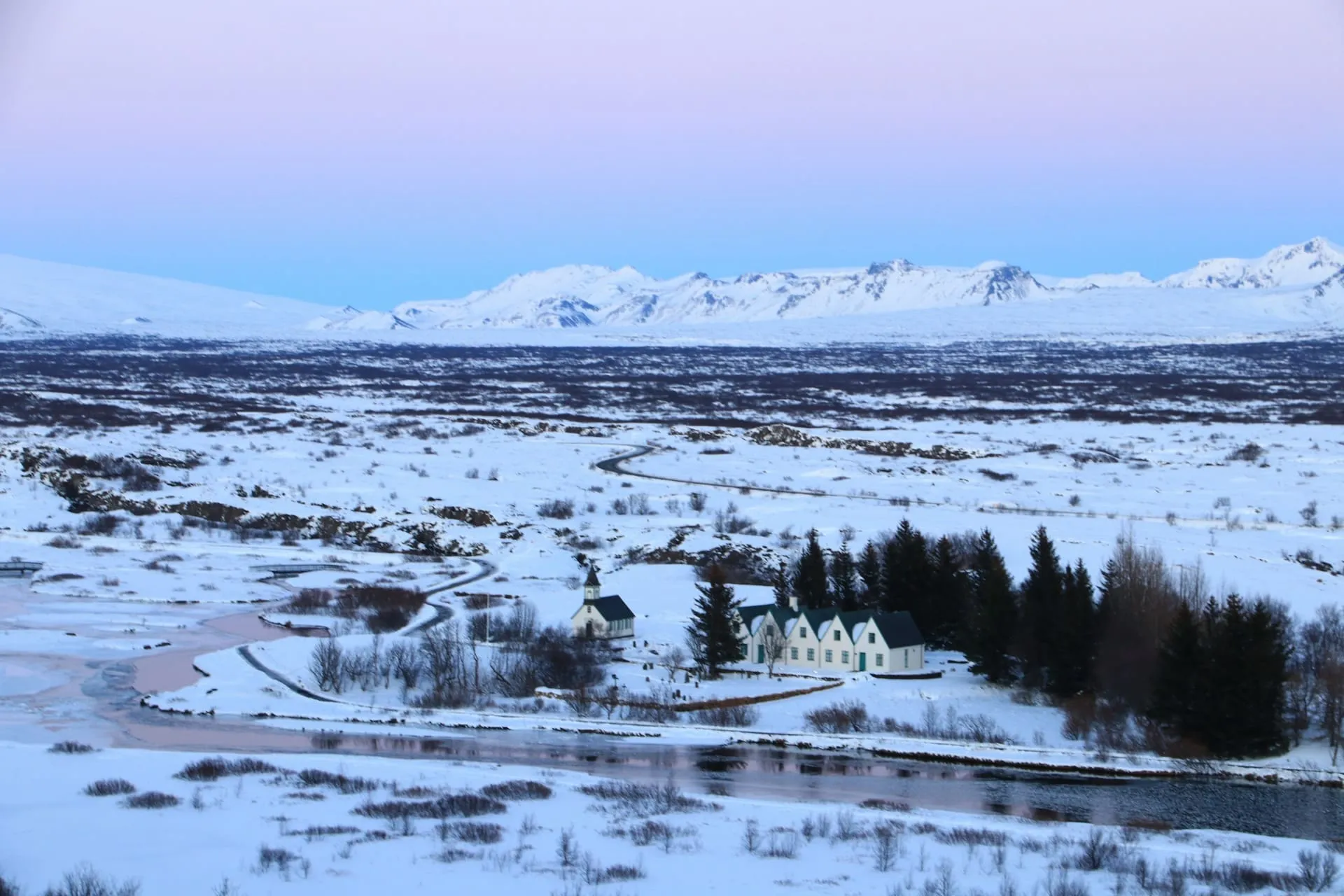 อุทยานแห่งชาติ Þingvellir ปกคลุมด้วยหิมะ มีโบสถ์และบ้านไม้สีขาวริมลำธาร